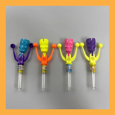 Esqueleto engraçado agitando o brinquedo de sino com doces frutados coloridos e prensados